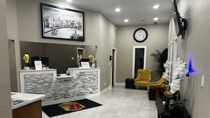 A reception area with a stone counter, a clock, and a reception desk.