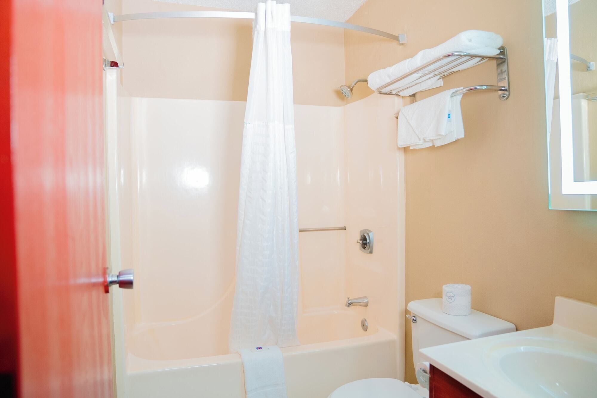 A bathroom with a shower, toilet, and sink.