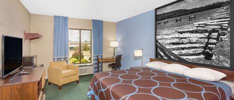 A hotel room with a bed, a desk, a chair, a television, and a large window.
