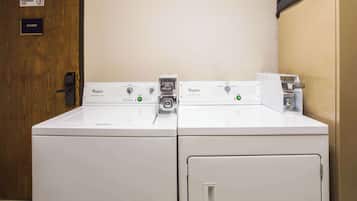 A laundry area with two Whirlpool washers and a coin-operated dryer.