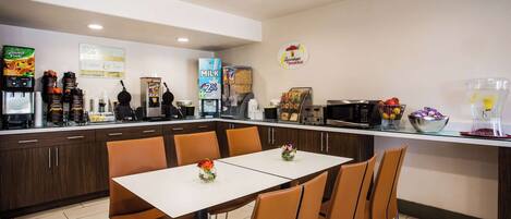 A breakfast area with a coffee machine, milk dispenser, and a sign for a special breakfast offer.