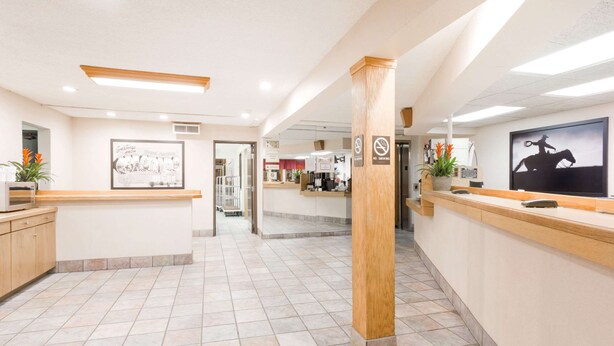 A reception area with a wooden reception desk, a framed welcome sign, and a no-smoking sign. - Super 8 by Wyndham Grand Junction Colorado (Grand Junction)