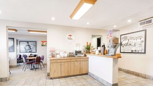 A clean, modern dining area with a wooden counter and chairs. - Super 8 by Wyndham Grand Junction Colorado (Grand Junction)