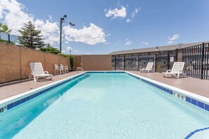 Una piscina al aire libre, tumbonas