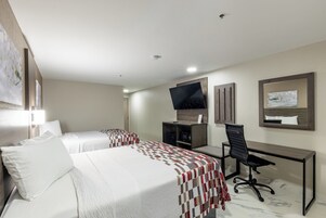 A hotel room with two beds, a desk, a chair, a television, and a painting on the wall.