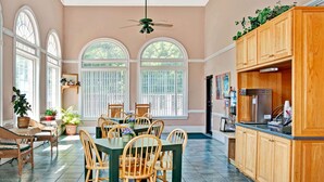 Une cuisine spacieuse avec un coin repas, comprenant une grande table, des chaises en bois et un buffet intégré en bois.