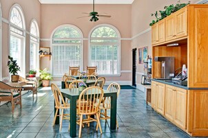 Una cocina amplia con comedor, que incluye una mesa grande, sillas de madera y un armario empotrado de madera.