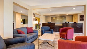 Eine Hotelhalle mit Empfangstresen, Sofas und einem Couchtisch.