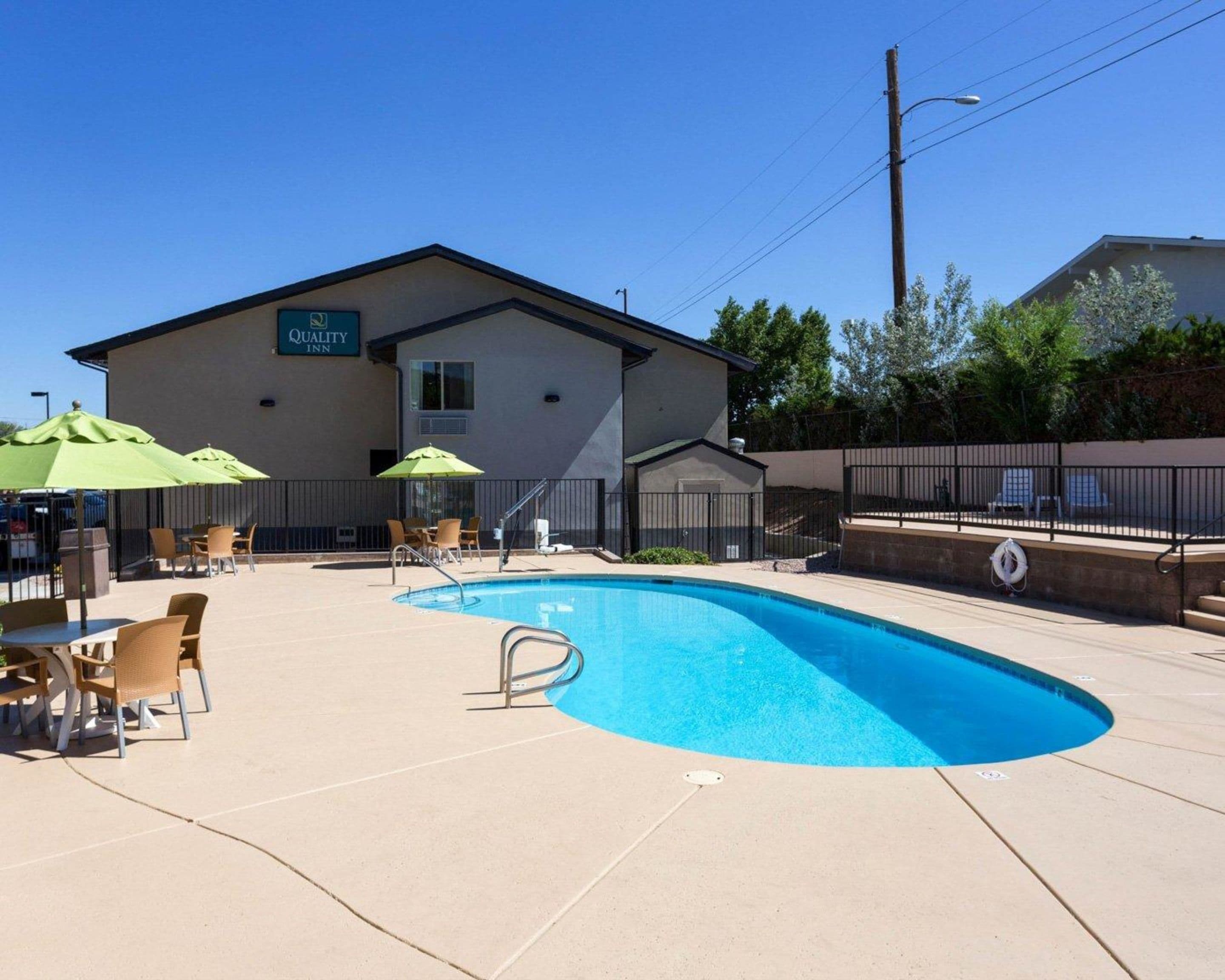 Un hôtel doté d’une piscine, d’un espace extérieur aménagé et d’une enseigne indiquant « Quality Inn ».