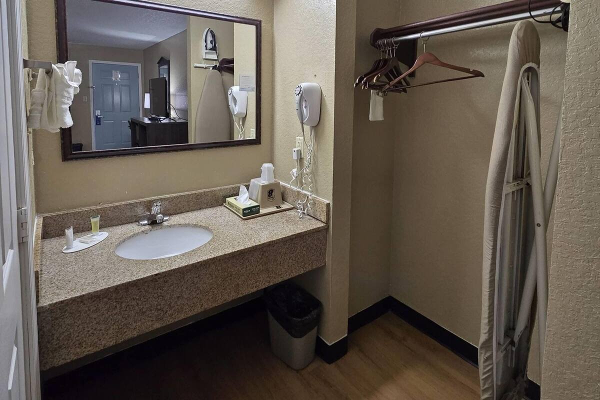 Une salle de bain équipée d’un lavabo, d’un miroir, d’un porte-serviettes et d’un rideau de douche.