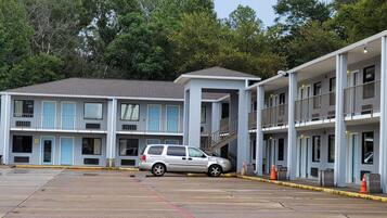 Un motel con varios pisos, un estacionamiento y una escalera que conduce a los niveles superiores.