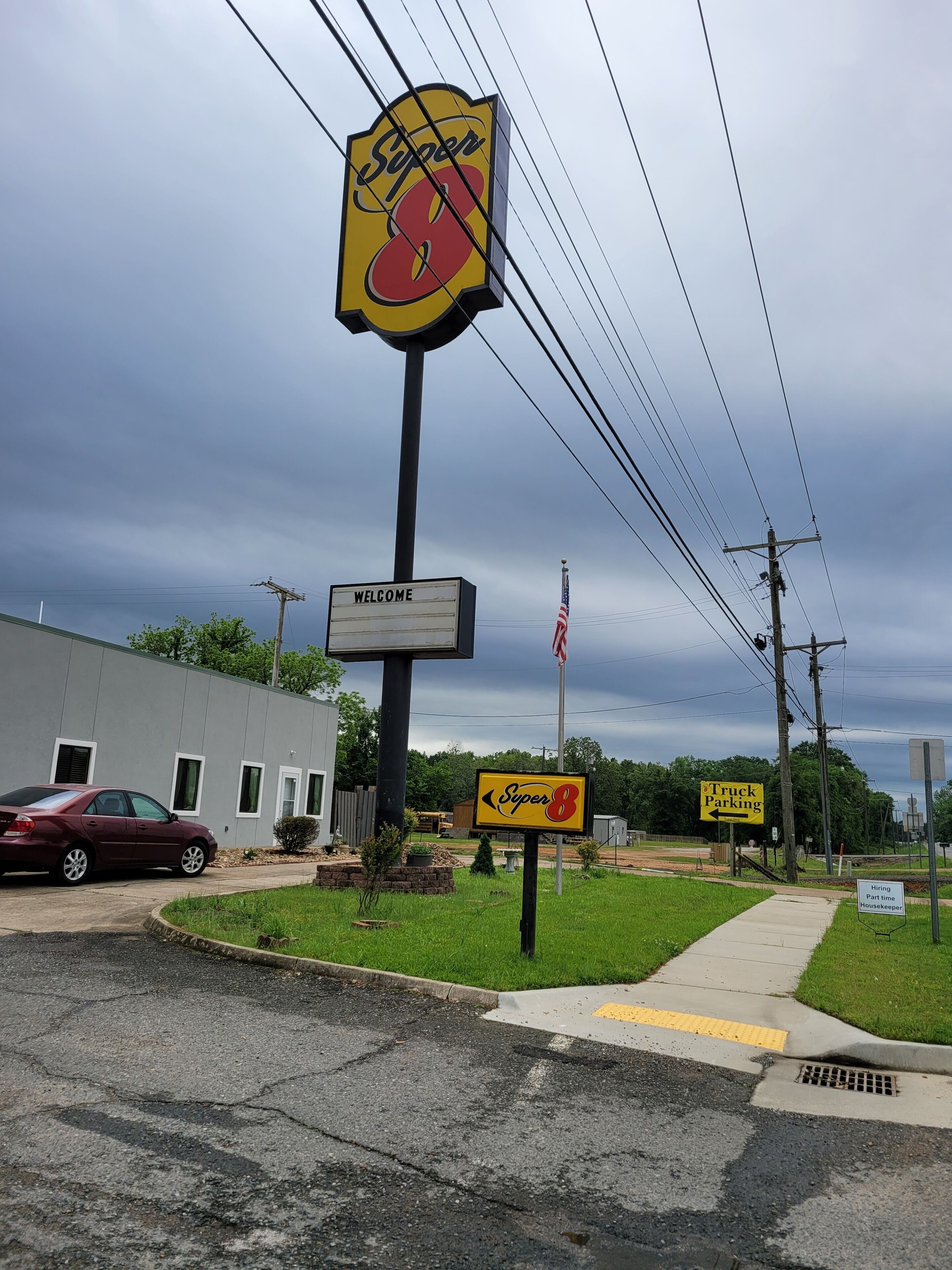 A Super 8 motel sign, a welcome sign, and a truck parking sign.