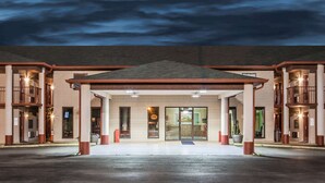 A hotel entrance with a covered walkway, multiple balconies, and a large entrance door.