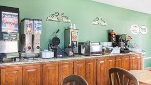 A breakfast bar with various food and drink dispensers, a waffle maker, and a coffee machine.