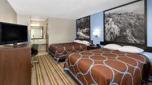 A hotel room with two beds, a TV, a desk, and a large framed picture on the wall.