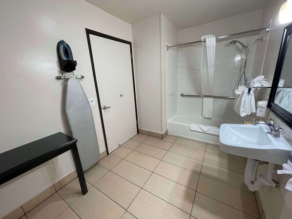 Un baño con ducha, lavamanos y espejo.