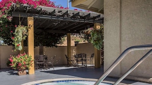 A hot tub area with a pergola, outdoor seating, and hanging plants. - Quality Inn Ontario Airport Convention Center (Ontario)