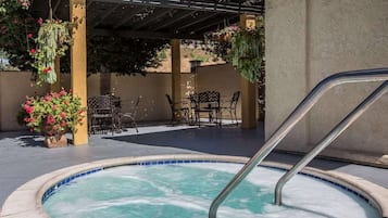 Een buitenzwembad, parasols bij het zwembad en ligstoelen