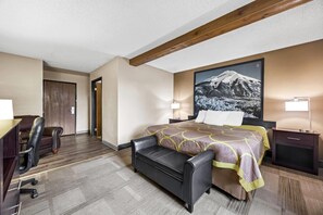A hotel room with a bed, a desk, a chair, a bench, and a nightstand with lamps. - Super 8 by Wyndham Colorado Springs Peterson Space Force (Colorado Springs)