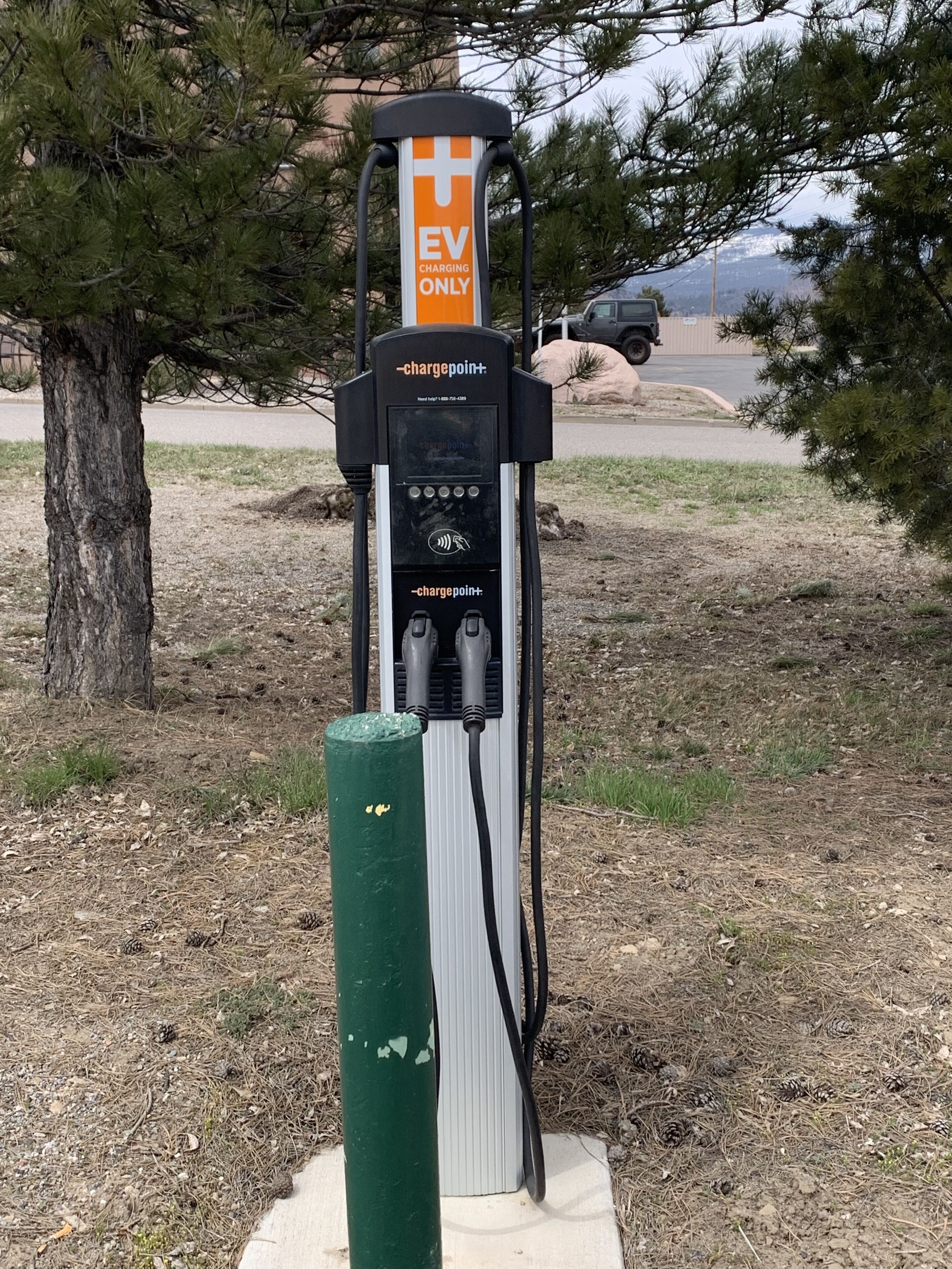 Una estación de carga para vehículos eléctricos con un signo '+', con la etiqueta 'SOLO CARGA DE VEHÍCULOS ELÉCTRICOS' y la marca 'chargepoint+' con un número de contacto.