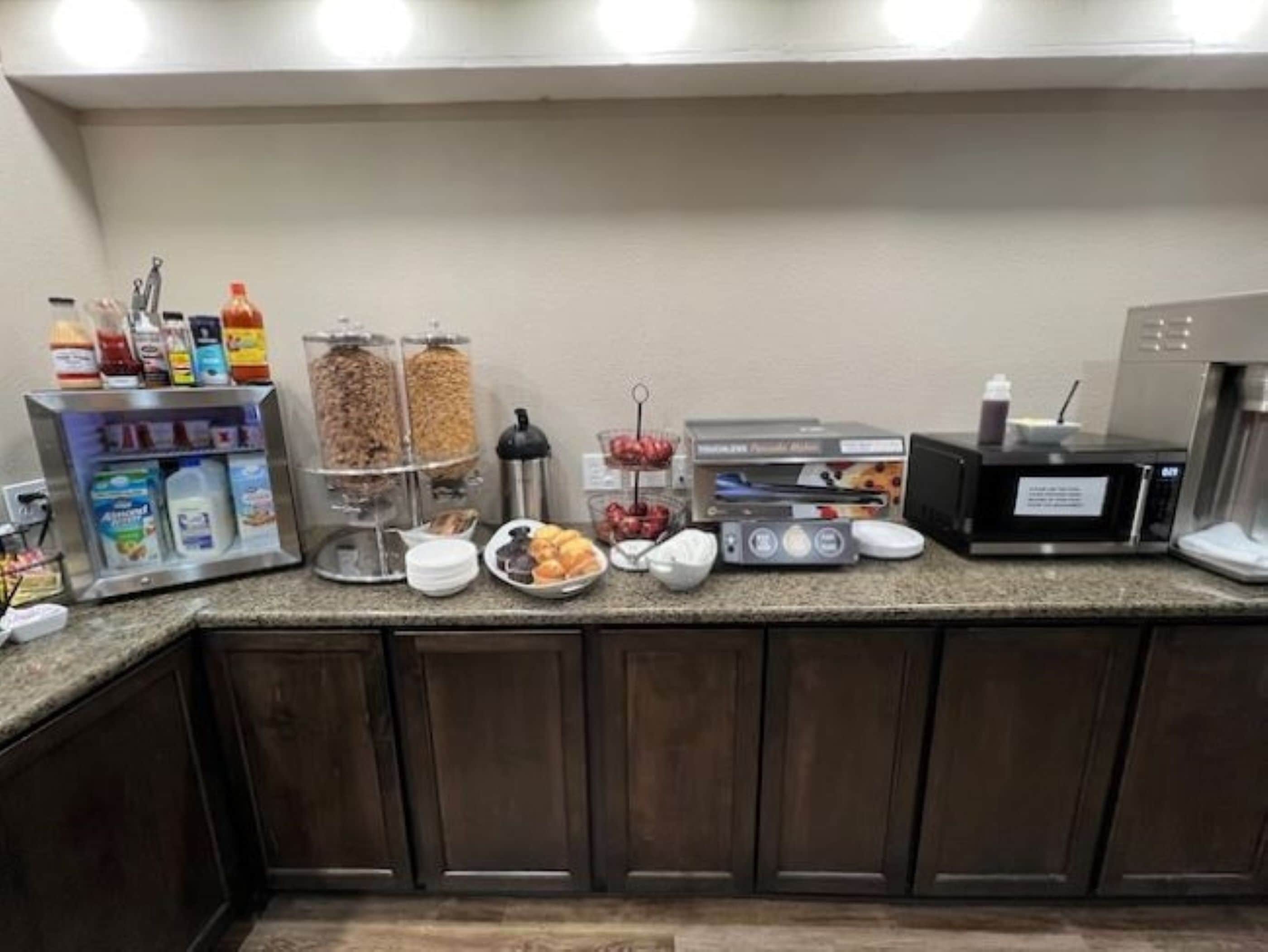 A breakfast bar with various food items and a coffee machine.