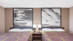 Ein Hotelzimmer mit zwei Betten, einem Nachttisch, einer Lampe und zwei großen abstrakten Bildern an der Wand.
