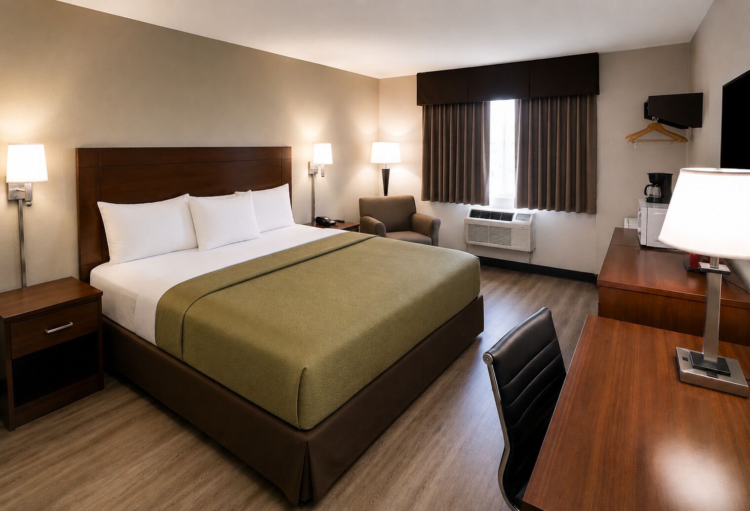 A hotel room with a bed, bedside tables, a desk, a chair, a TV, and a window with curtains.