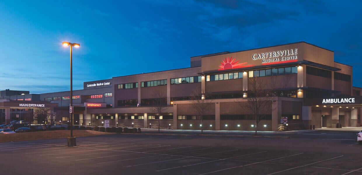 A medical center building with a main entrance, emergency department, and ambulance area.