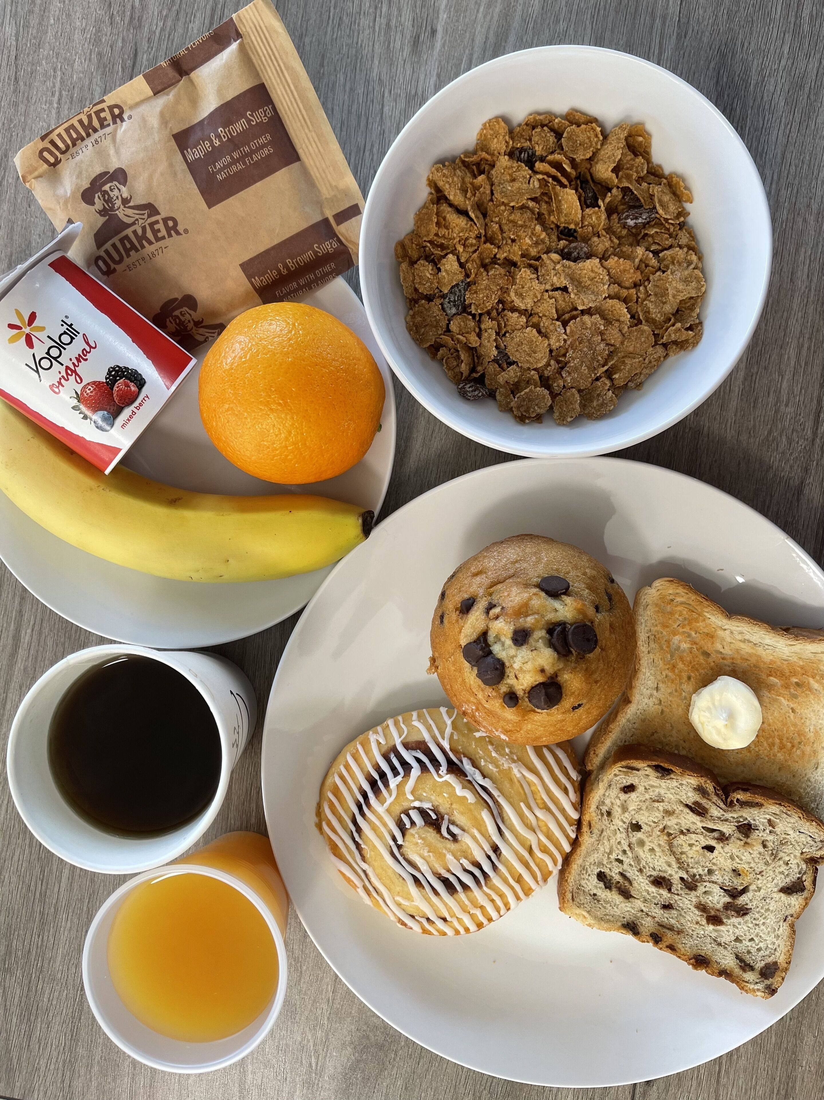 Desayuno con cereal, naranja, plátano, café y pastelería.