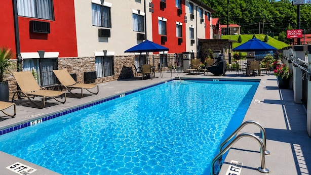 A swimming pool with a 5 ft depth marker, lounge chairs, and umbrellas. - Econo Lodge Cartersville-Emerson Lake Point (Cartersville)