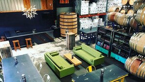 A bar area with wooden barrels, green sofas, and yellow stools. - Econo Lodge Cartersville-Emerson Lake Point (Cartersville)