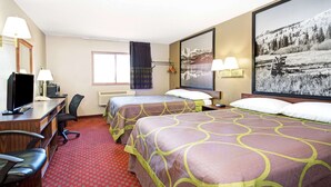 Une chambre d’hôtel avec deux lits, un bureau avec un ordinateur, une chaise et un grand tableau encadré au mur.
