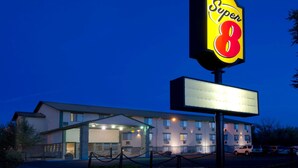 A Super 8 hotel with a large illuminated sign, a covered entrance, and a parking lot.