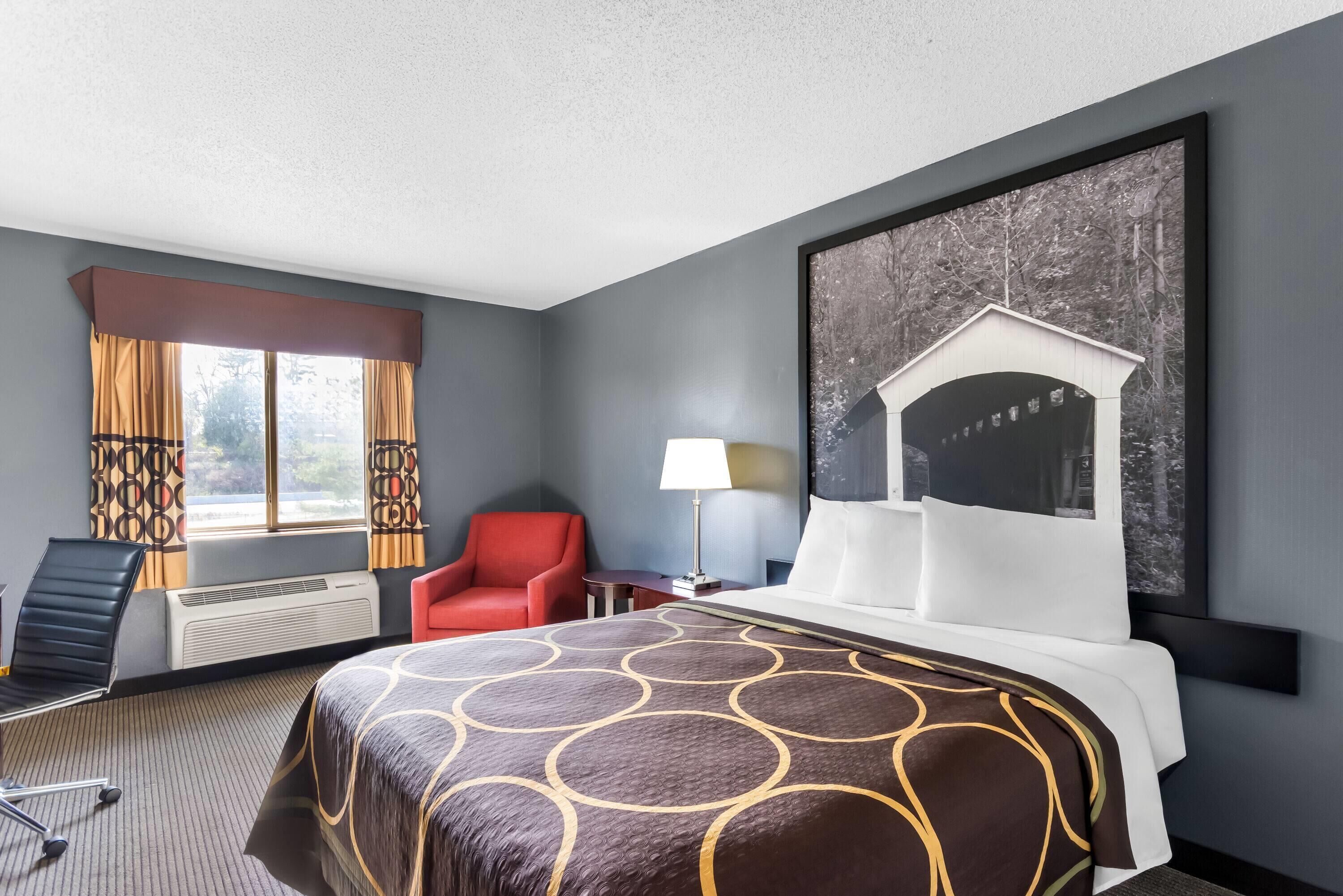 Escritorio, cortinas opacas, tabla de planchar con plancha