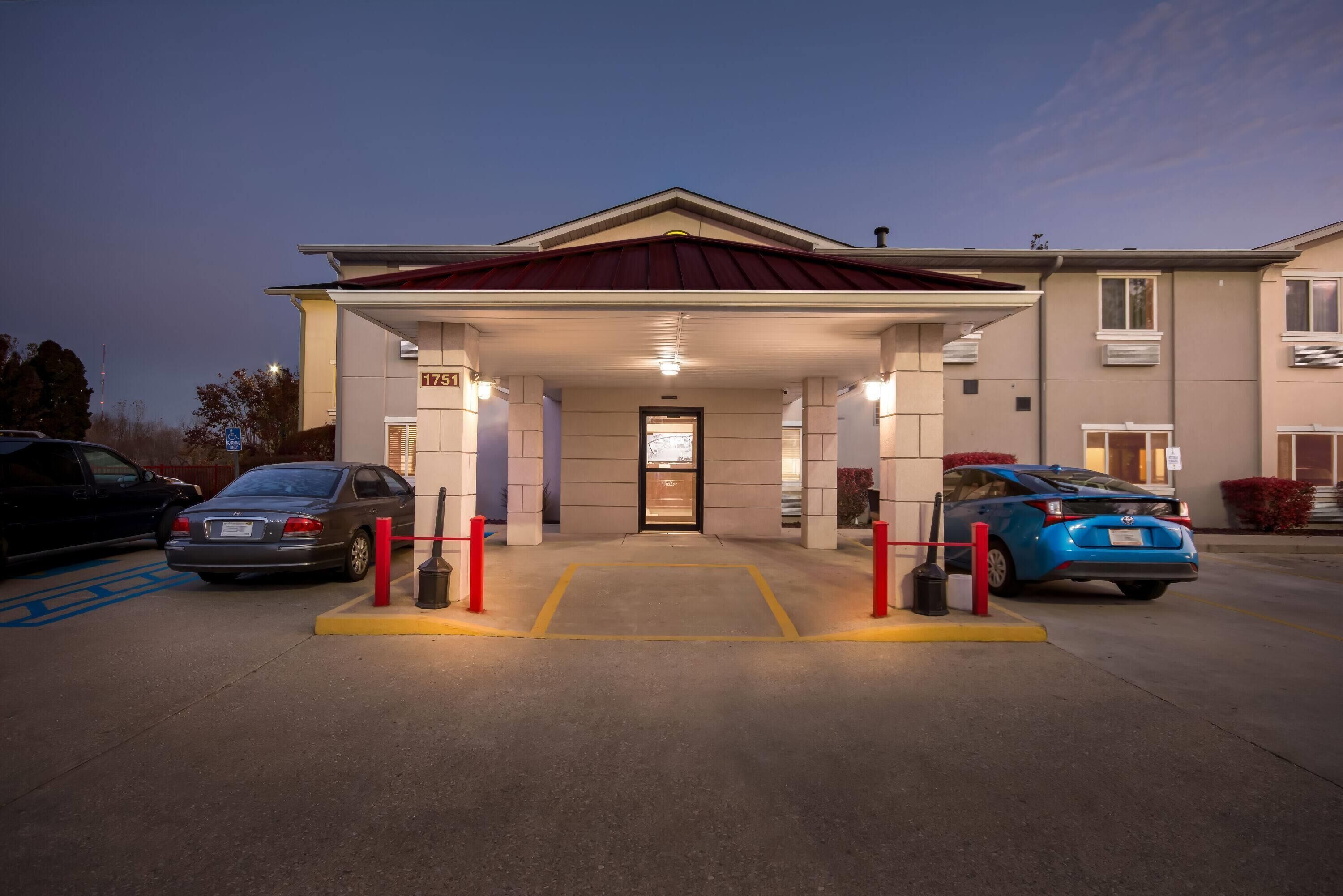 A hotel entrance with a covered driveway, marked parking spaces, and a building number 1751.