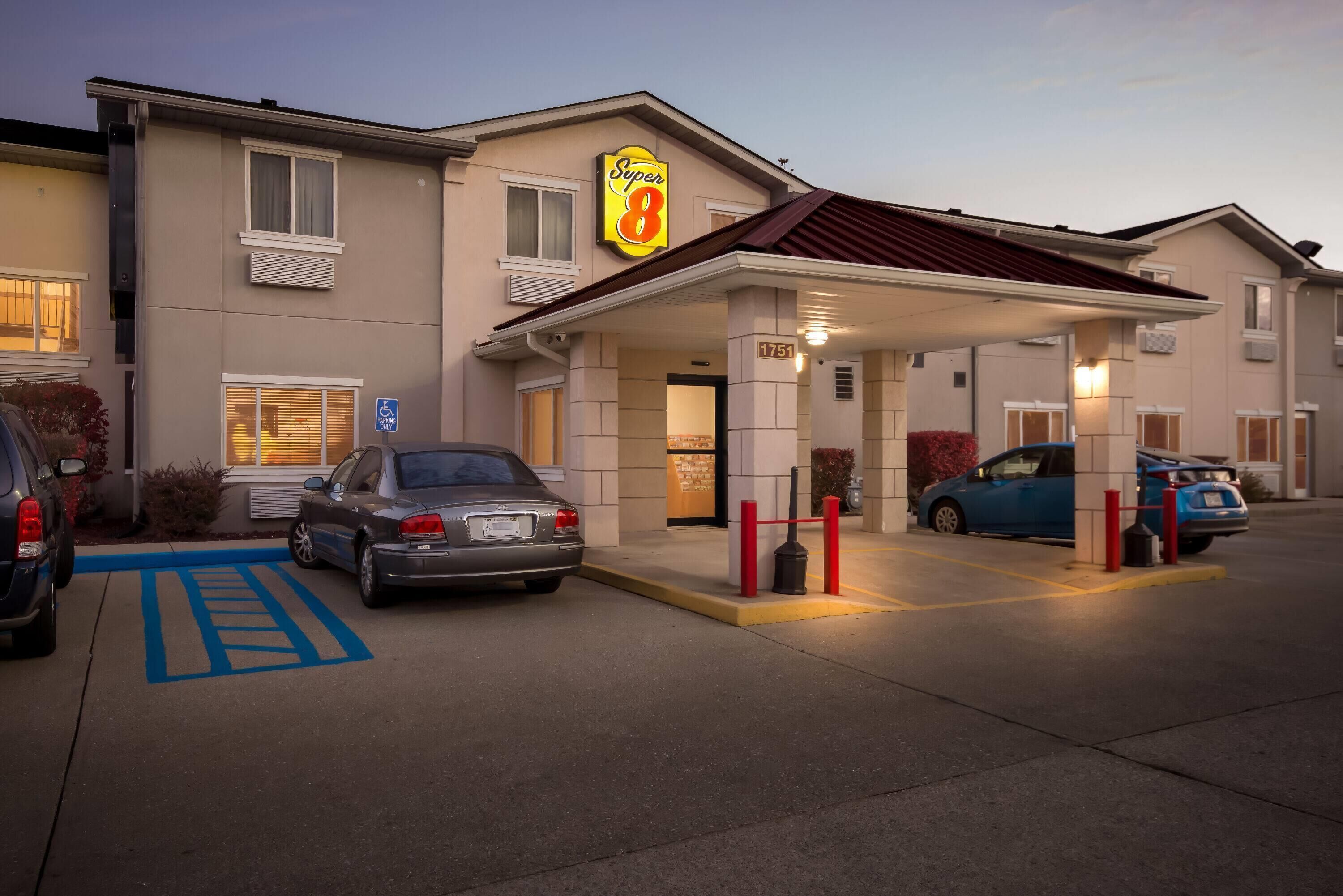 Een hotel met een Super 8 bord, een overdekte ingang en een parkeerplaats voor mensen met een handicap.