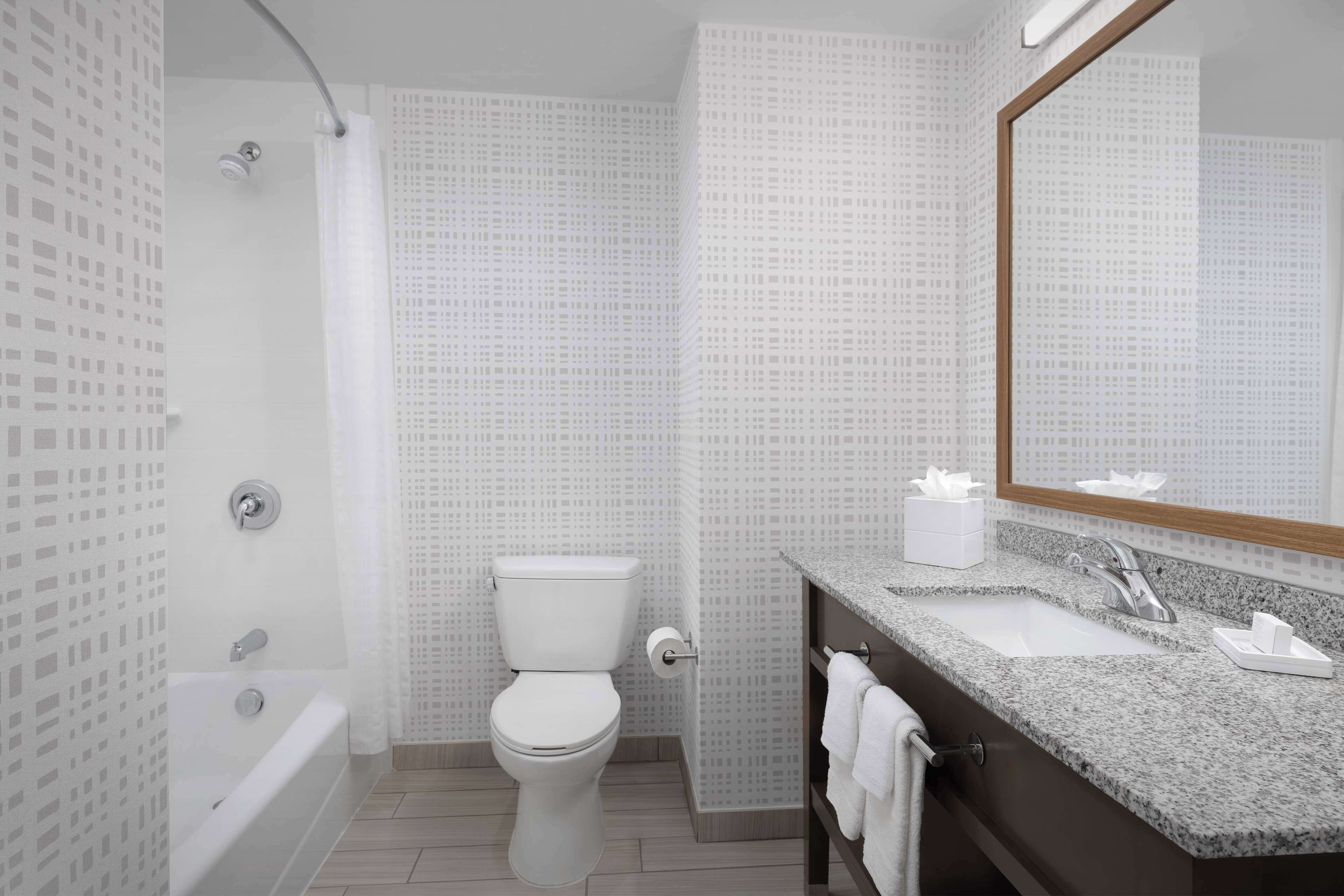A modern bathroom with a bathtub, toilet, and sink.