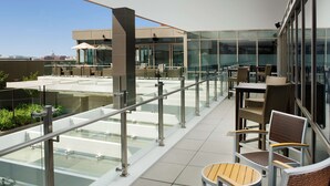 A rooftop terrace with glass railings, outdoor seating, and a view of the city skyline. - Hampton Inn Washington DC NoMa Union Station (Washington)