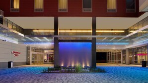A hotel lobby with a large water feature, glass railings, and a red-brick facade. - Hampton Inn Washington DC NoMa Union Station (Washington)