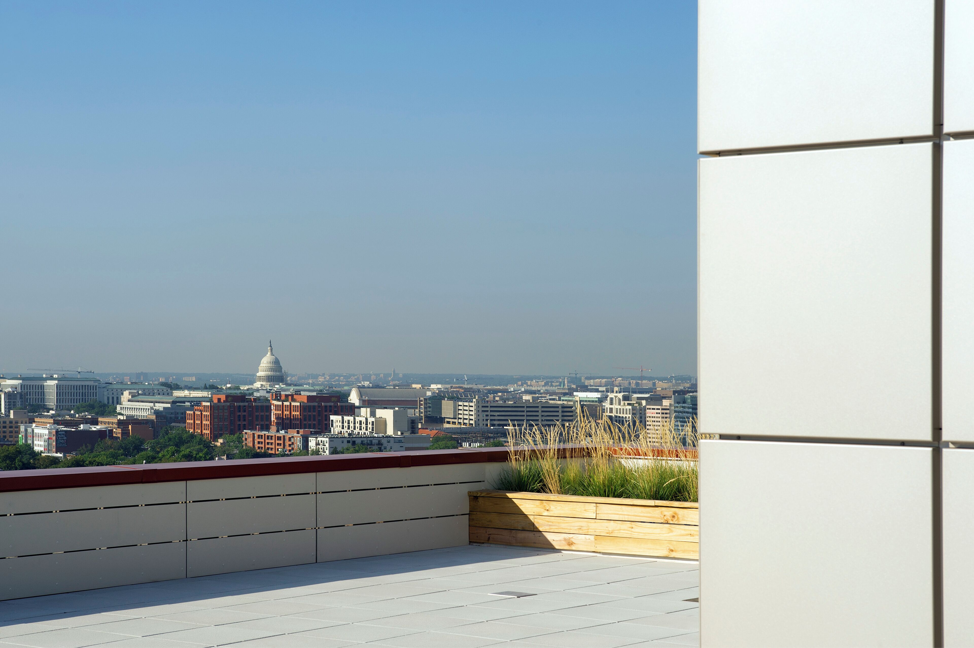 Terraza en la azotea con vistas a un paisaje urbano, incluyendo un edificio con una cúpula destacada.