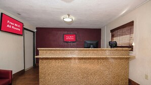 A reception desk with a sign indicating free Wi-Fi in all rooms. - Red Roof Inn Jacksonville - Cruise Port (Jacksonville)