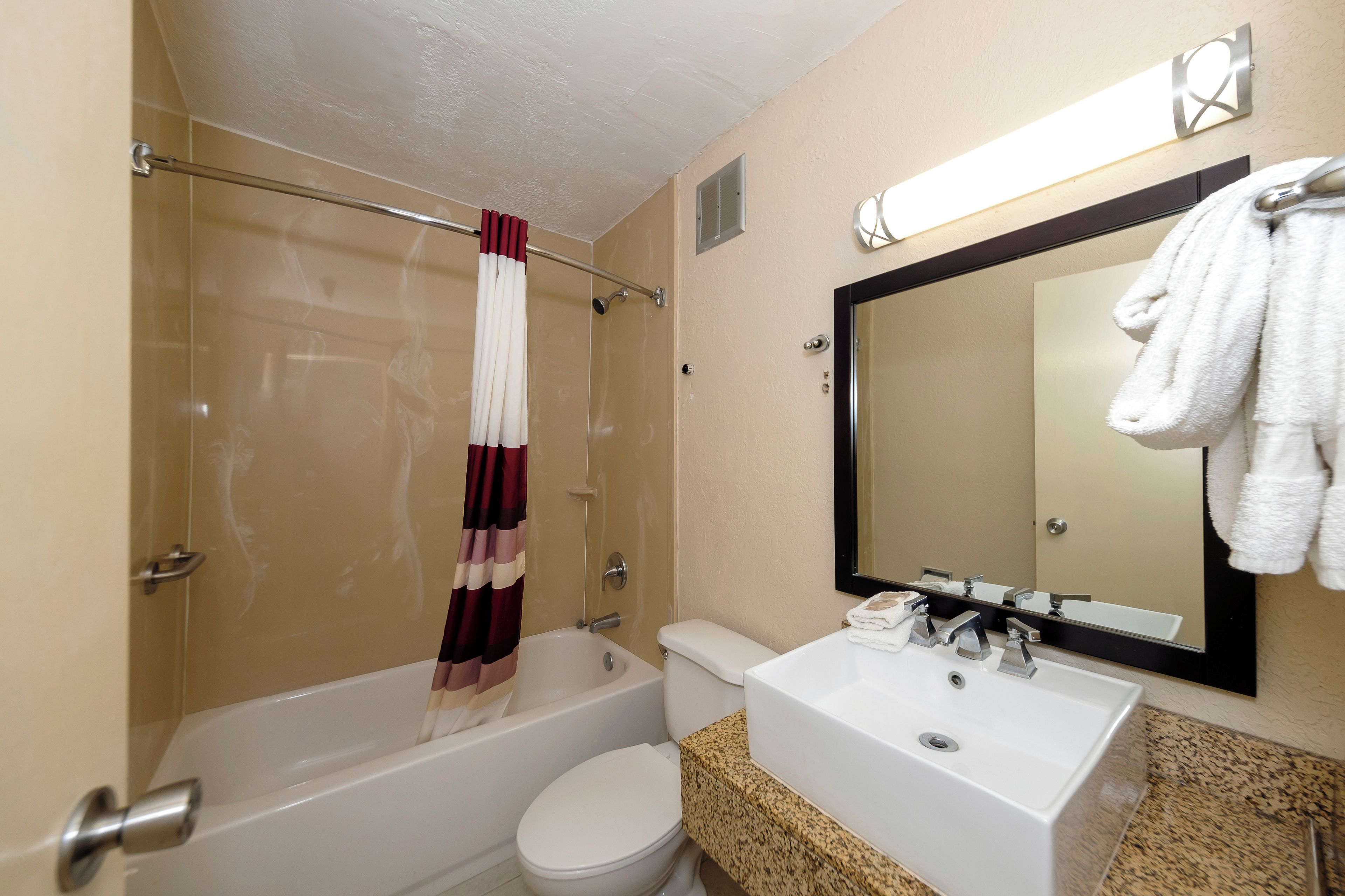 A bathroom with a bathtub, toilet, and sink.