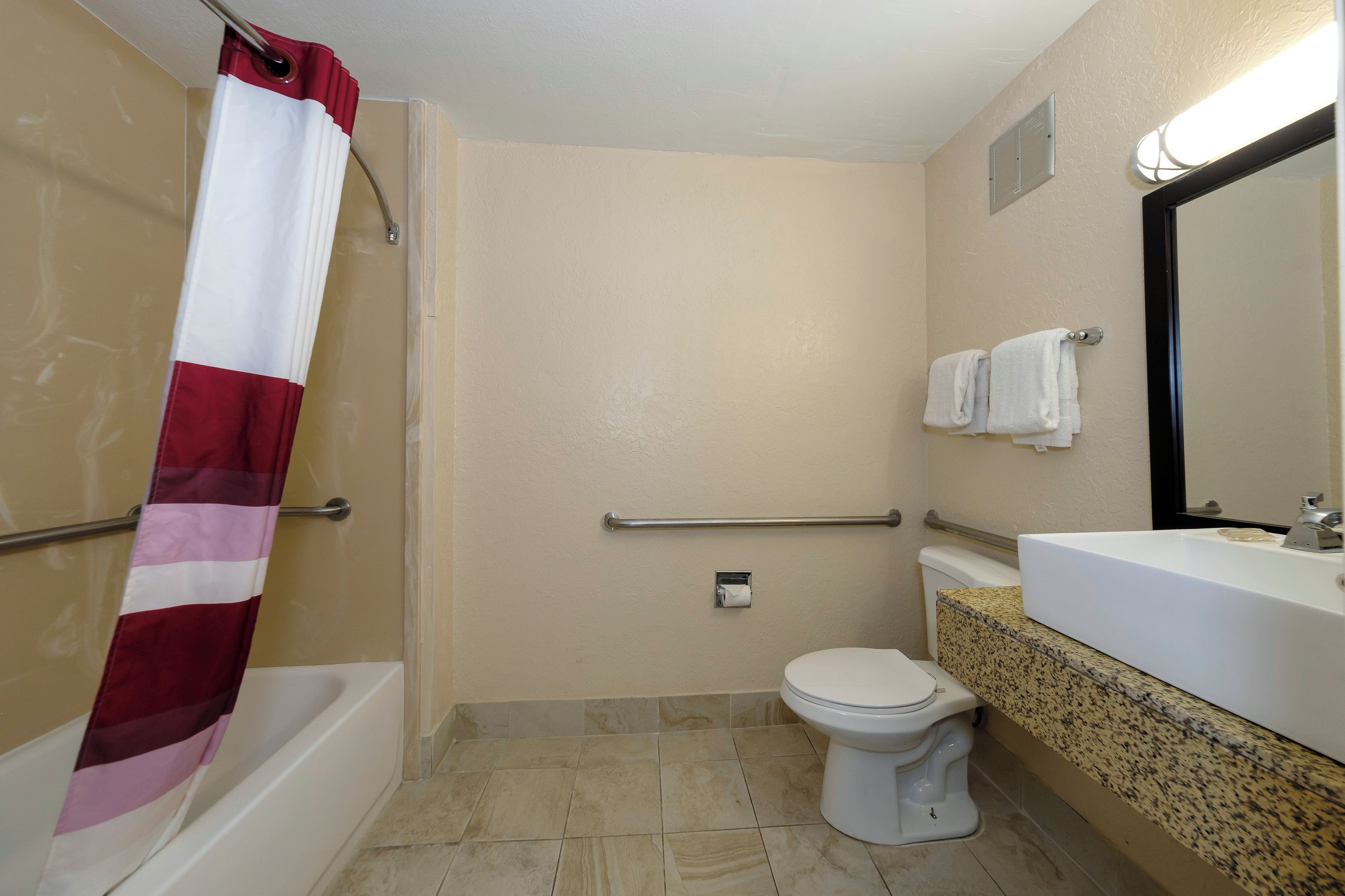 Une salle de bain avec douche, toilettes et lavabo.