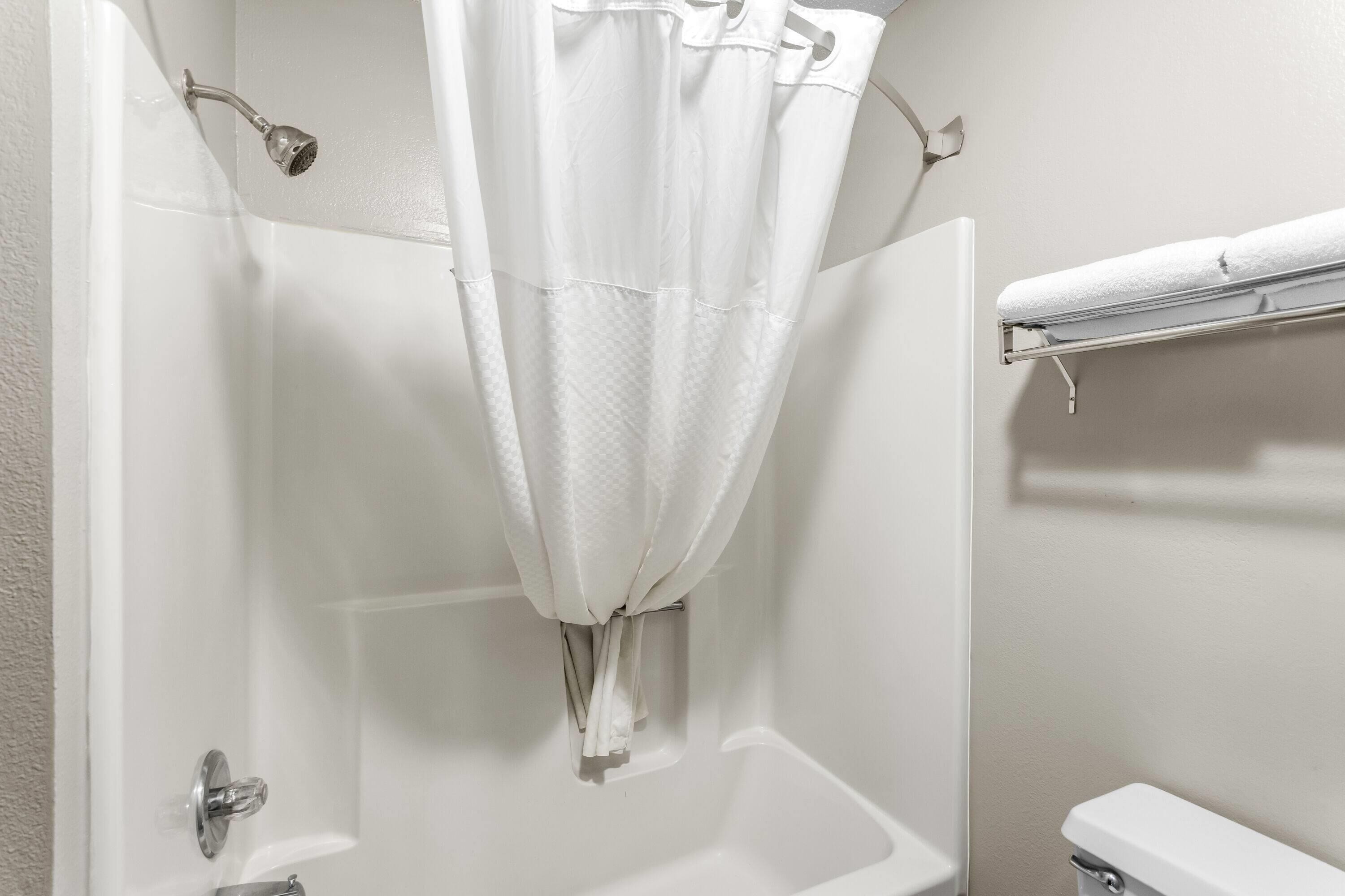 Un baño con bañera, cortina de ducha y barra para toallas.
