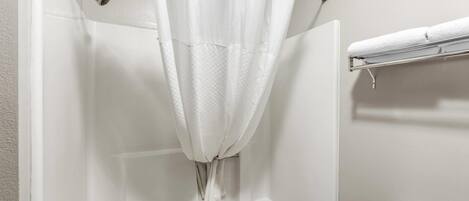 Un baño con bañera, cortina de ducha y barra para toallas.