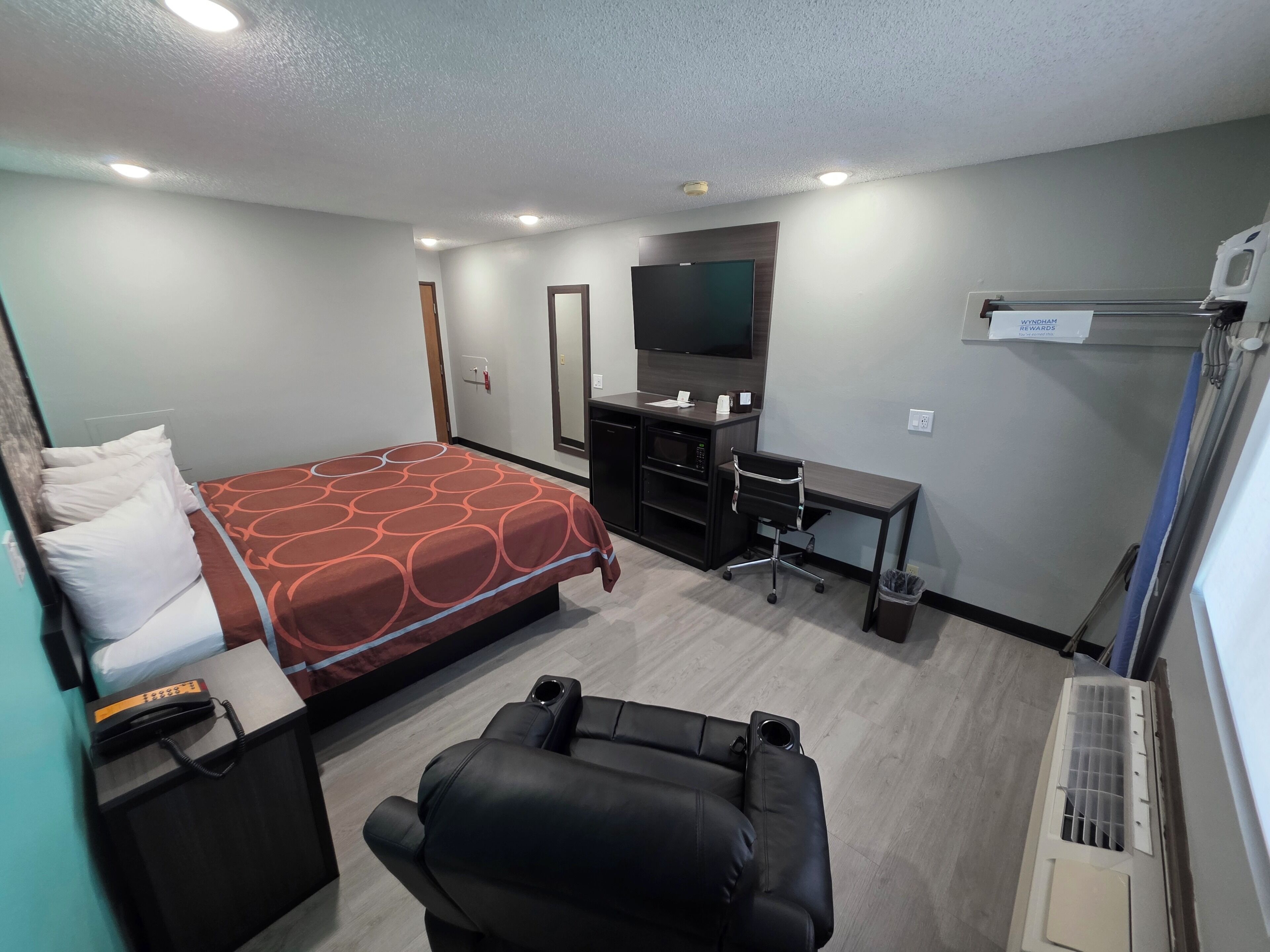 Een hotelkamer met een bed, bureau, stoel en televisie.