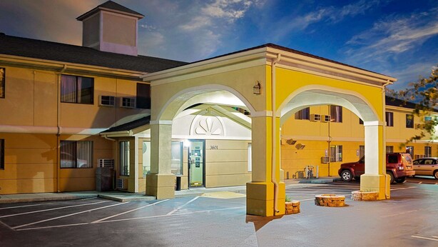 A hotel entrance with a covered parking area, numbered 3601, and a clear sky.