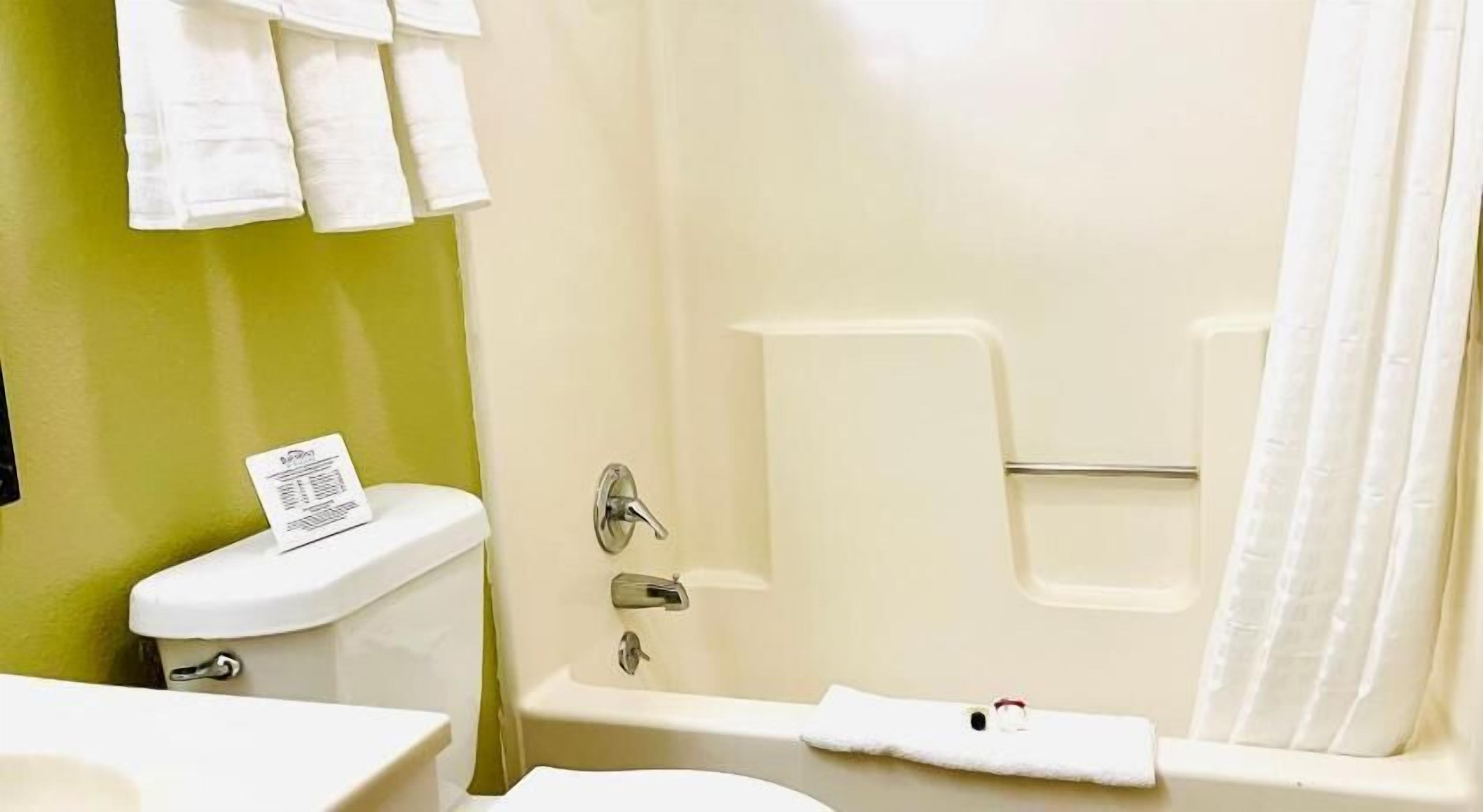 Une salle de bain avec des toilettes, une baignoire et un lavabo.