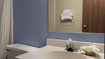 A bathroom with a white sink, a mirror, and a wooden door.