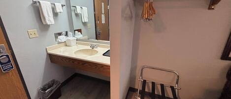 A bathroom with a sink, mirror, and towel rack.
